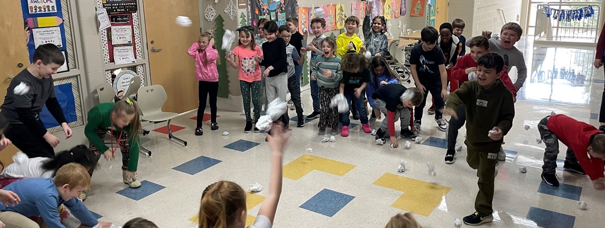 Students who met their reading goals in December participate in an indoor snowball fight!