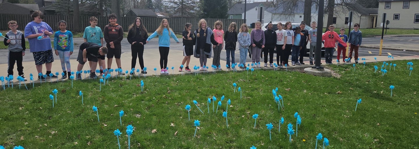 Students plant blue pinwheels in recognition of National Child Abuse Prevention Month